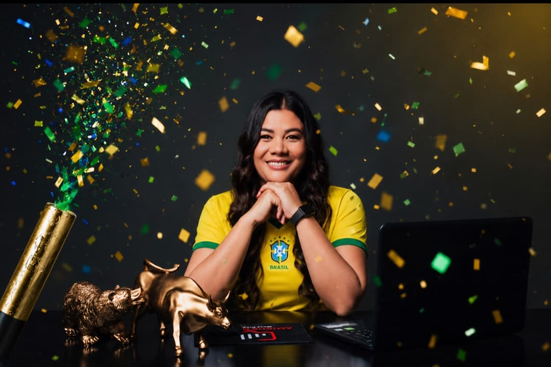 Fundadora da Amigos da Mesa Prop sentada à mesa com estátuas de touro e urso dourados